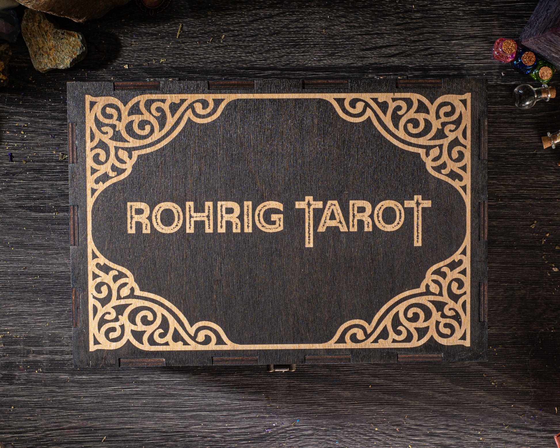 A wooden box with the name "Rohrig Tarot" embossed on it, placed on a wooden surface.