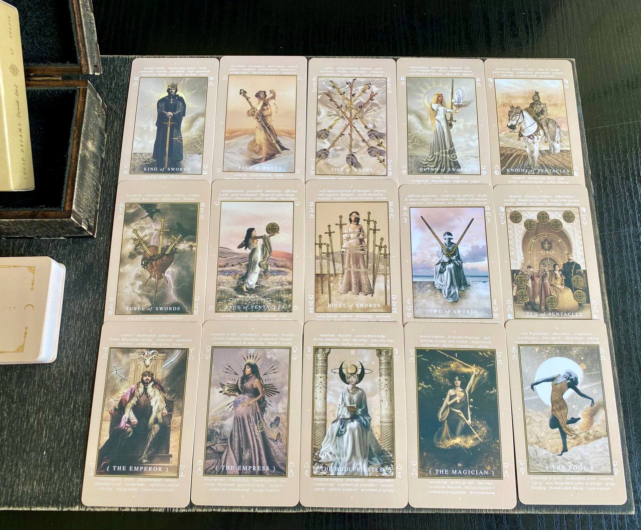 a collection of tarot cards arranged on a wooden surface.