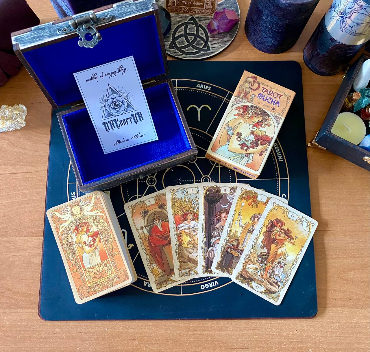 a collection of tarot cards and a blue box with a white label, arranged on a wooden surface.