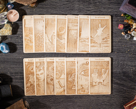 A collection of wooden tarot cards with intricate designs and illustrations, arranged on a dark wooden surface.
