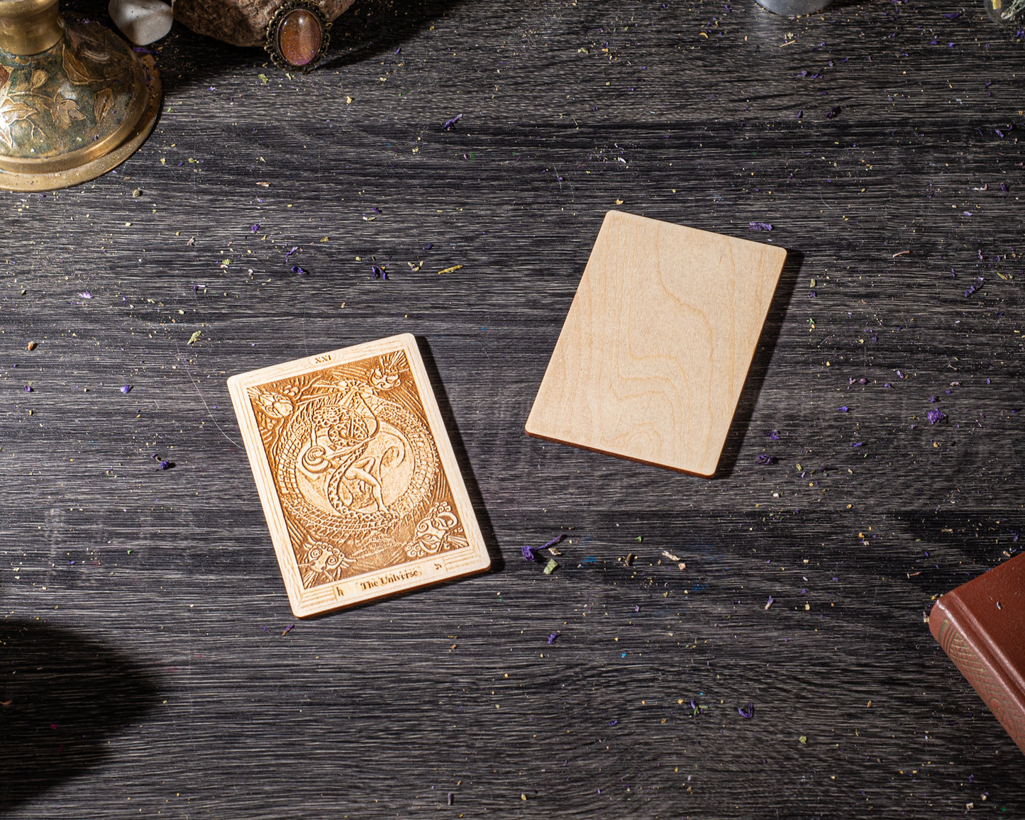 a wooden card with an intricate design and the text "The Oracle" on it, placed on a wooden surface. There is also a wooden block or coaster next to the card.