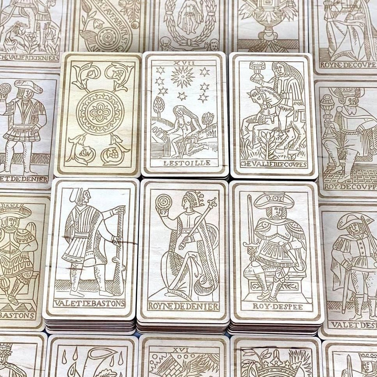 a collection of wooden tarot cards arranged in a grid-like pattern.