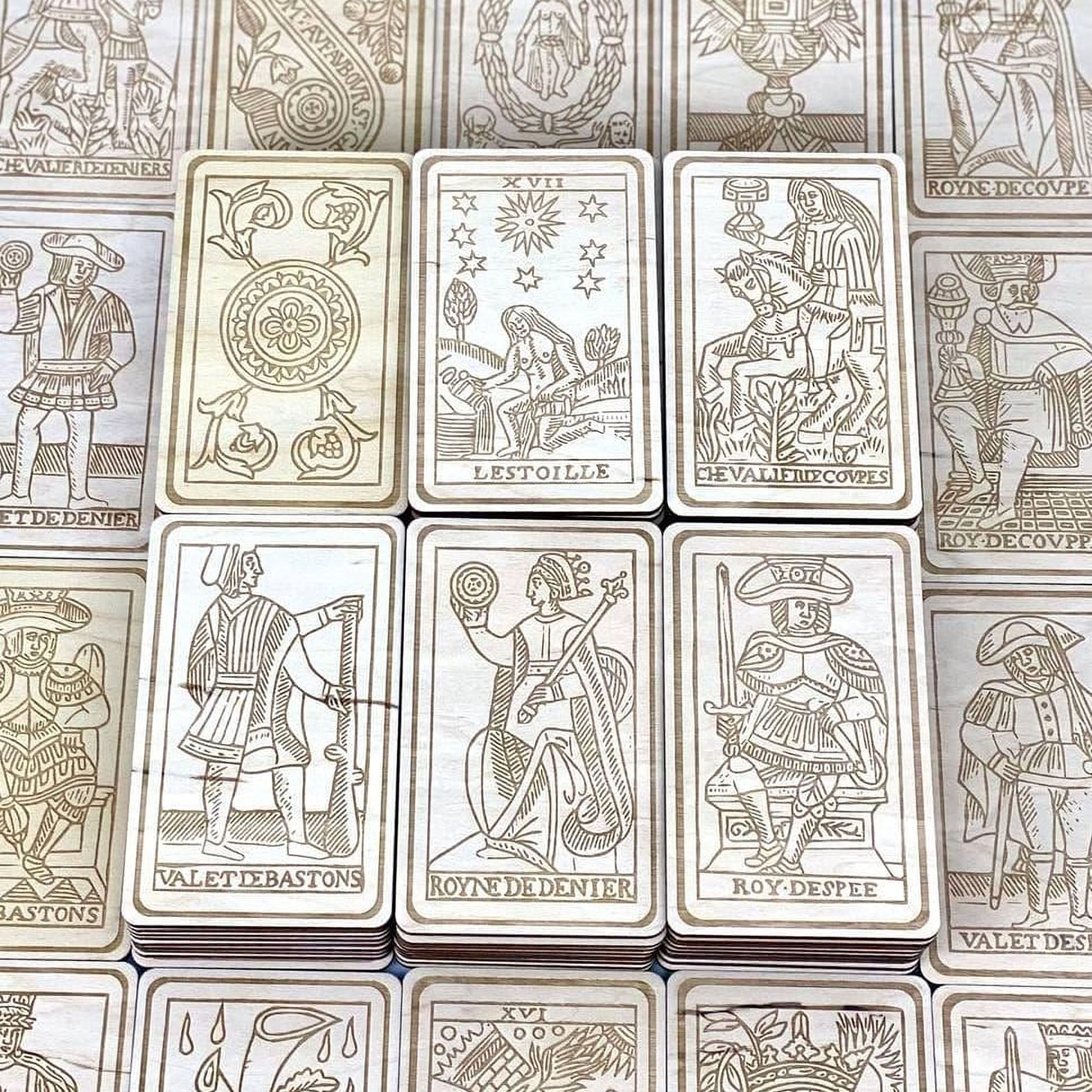 a collection of wooden tarot cards arranged in a grid-like pattern.
