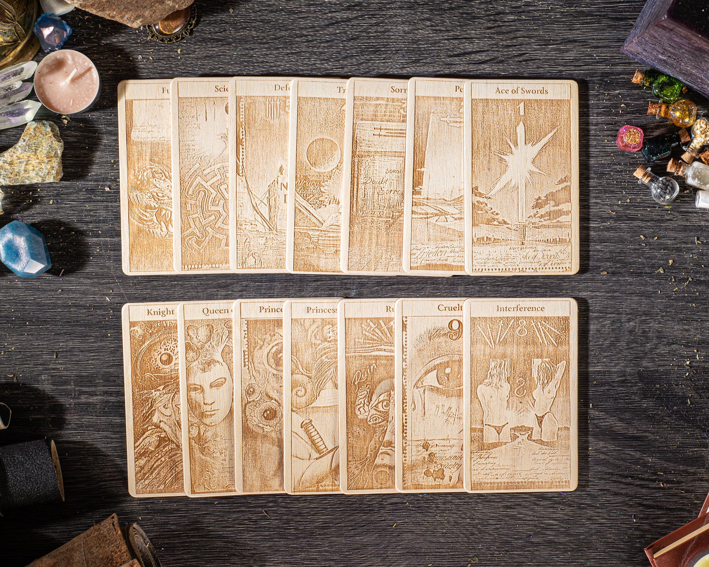 A collection of wooden tarot cards with intricate designs and illustrations, arranged on a dark wooden surface.