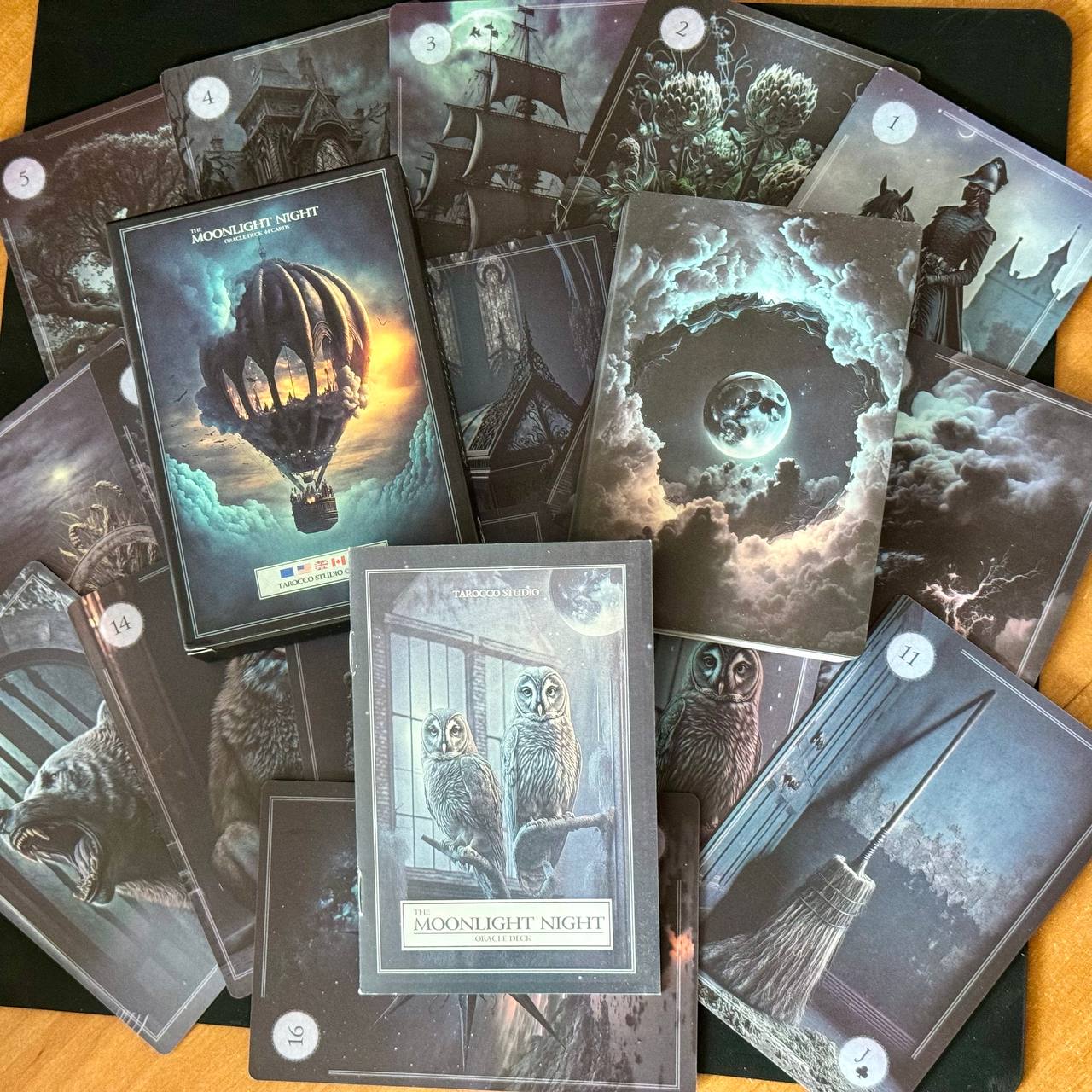 a collection of tarot cards with various illustrations, including a hot air balloon, a castle, a moon, and owls.