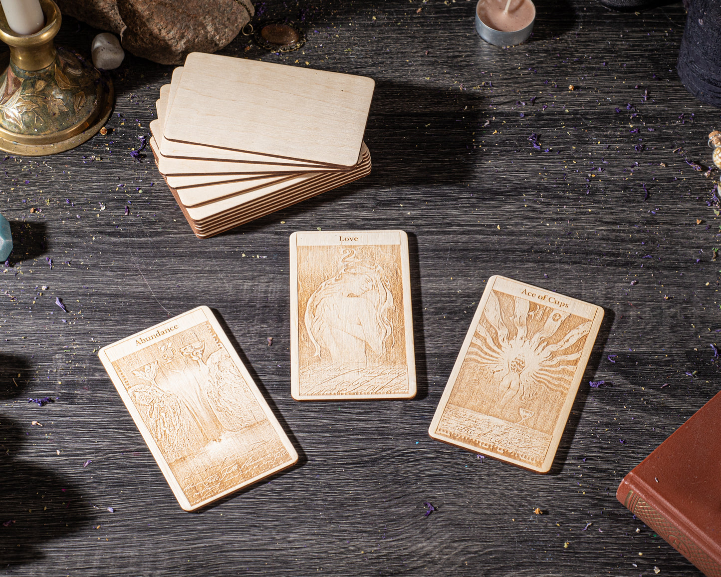 three wooden tarot cards with intricate designs, placed on a dark wooden surface.