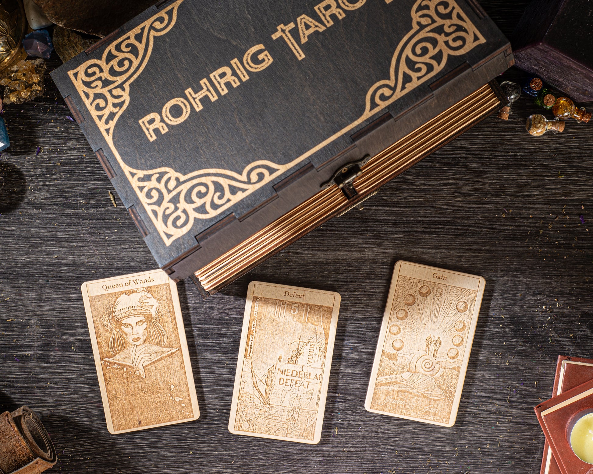 a wooden box with intricate designs, three wooden tarot cards, and various objects on a wooden surface.