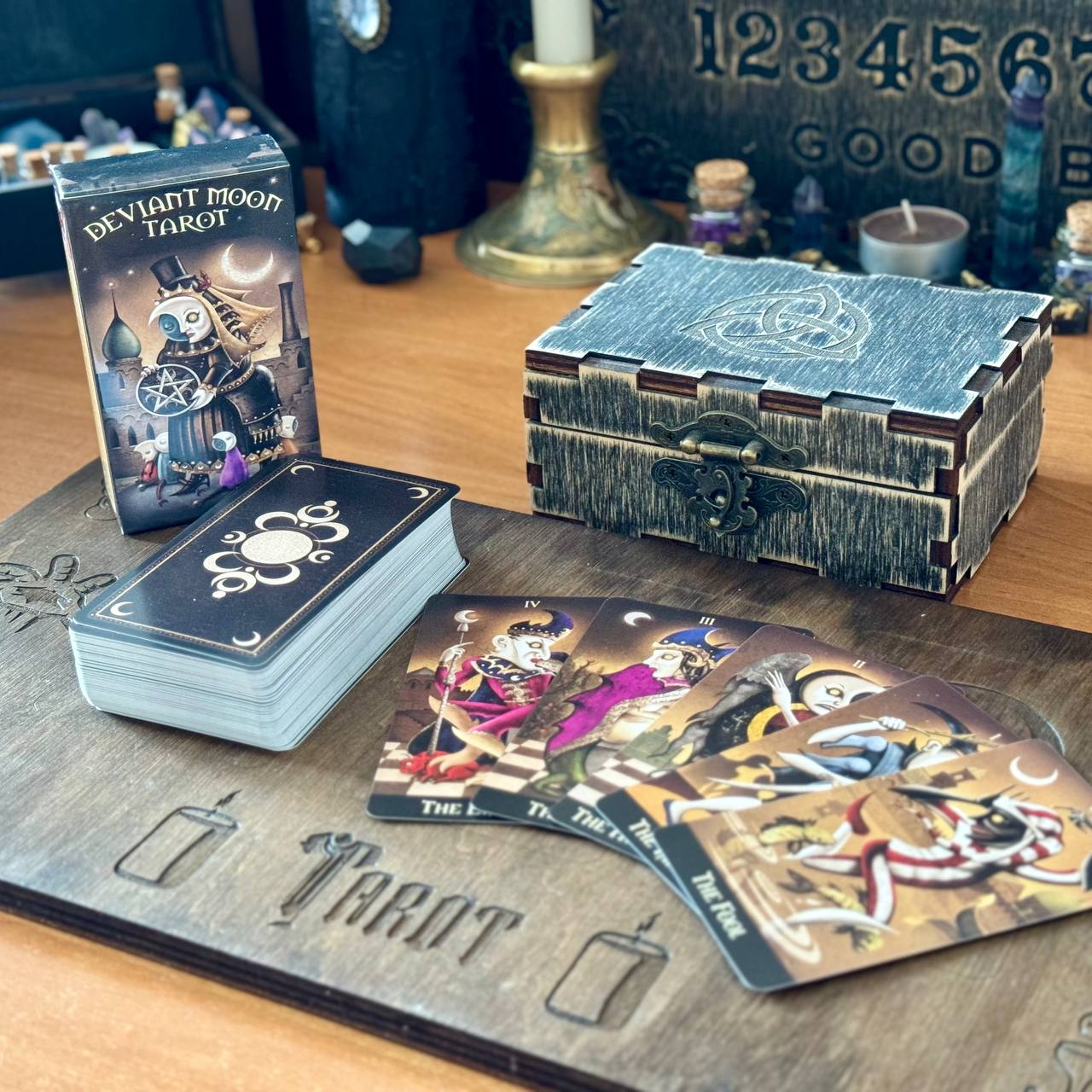 a tarot deck, a wooden board with a tarot card reading, and a wooden box with a tarot card reading setup.