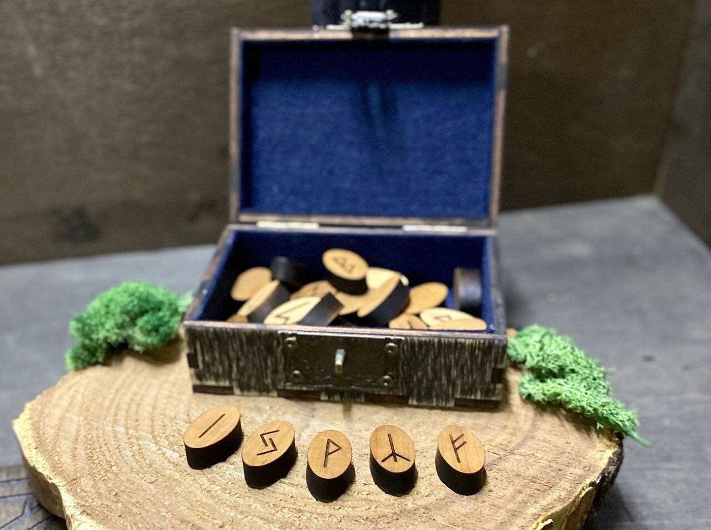 a wooden box with a blue interior, containing several wooden pieces, and a wooden board with the word "ISP" carved into it.