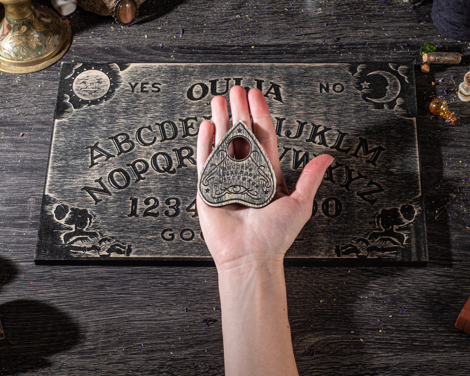 Hands using wooden ouija board during a spiritual seance and divination ritual