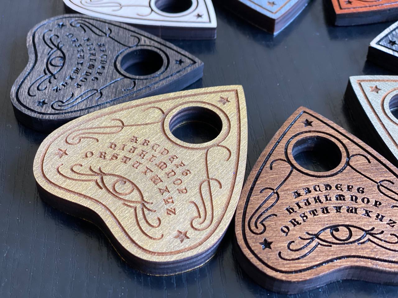 Ouija planchette in natural wood and metallic finishes