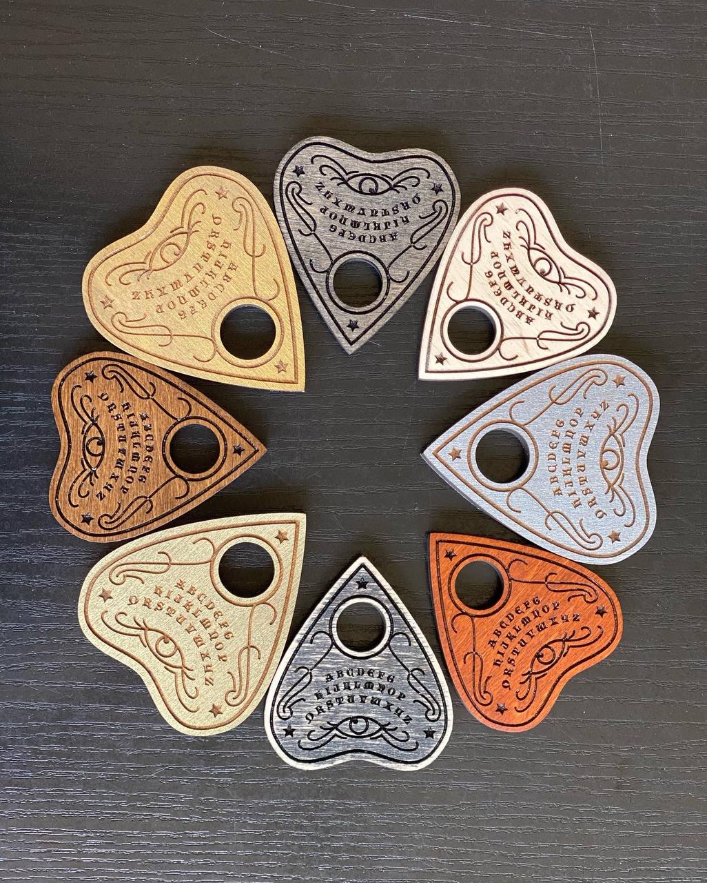 Handcrafted wooden ouija planchettes on neutral background